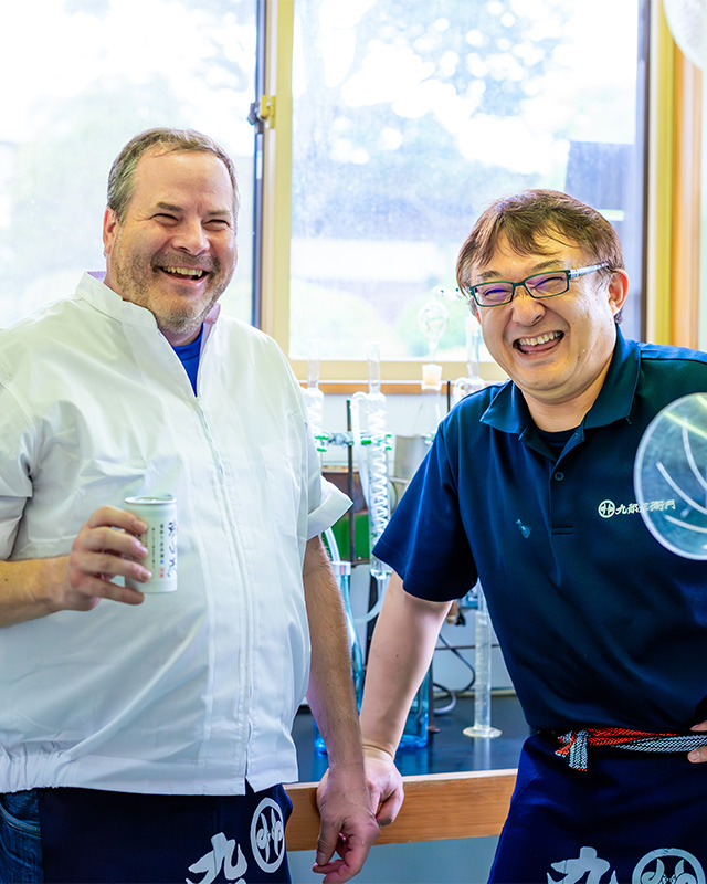 Stuart Morris and Masanobu Shindo laughing in the lab while sampling sake